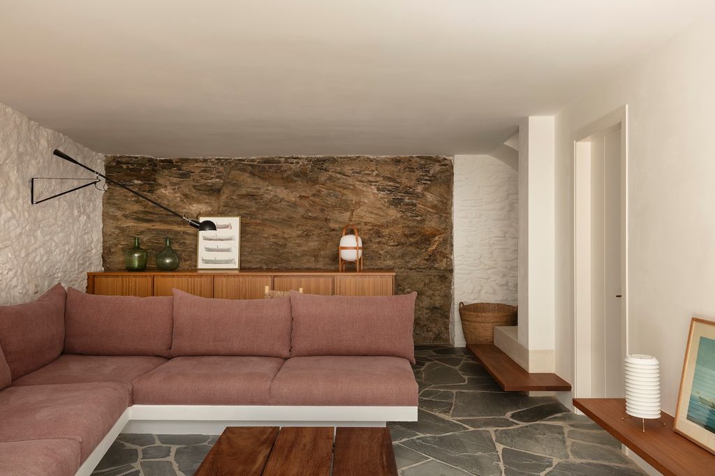Salón con pared de piedra y suelo de pizarra. 