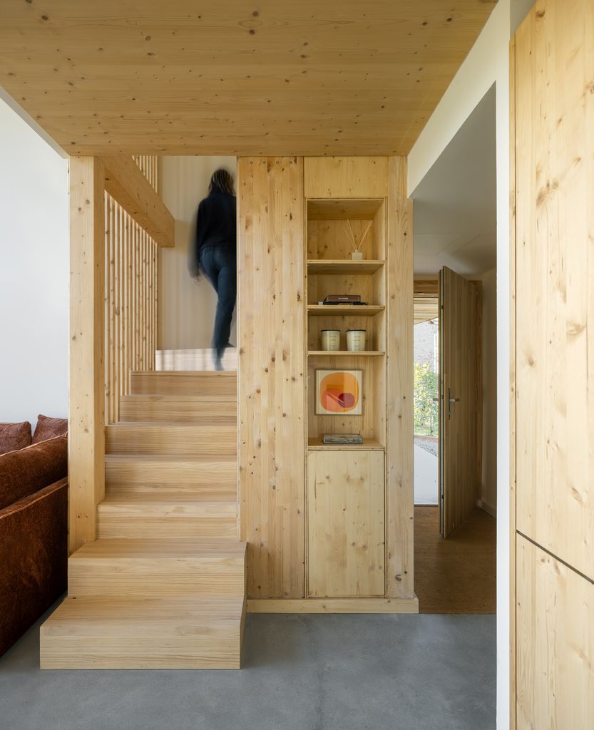 Escalera de madera que conduce a dos dormitorios y un despacho