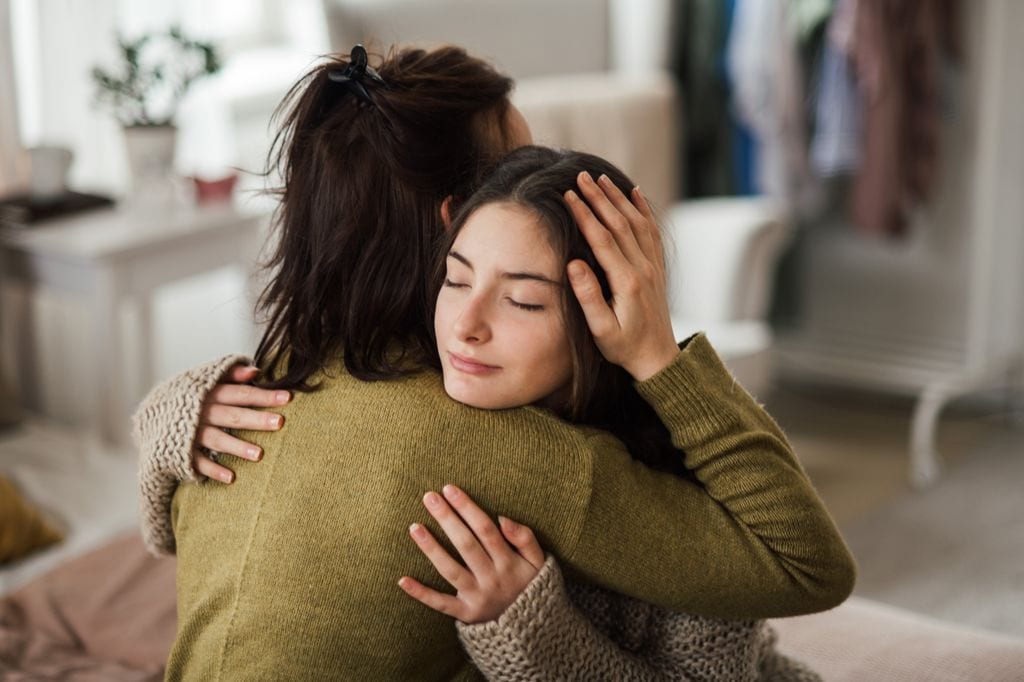 Adolescente abrazada a su madre