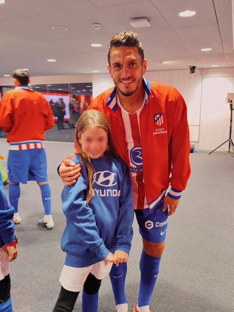 La pequeña llena de ilusión junto al capitán del equipo, Koke