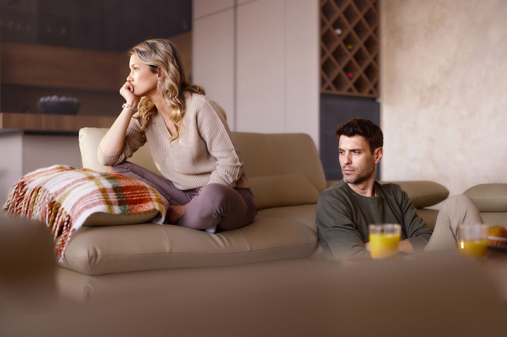 pareja que acaba de discutir, en el salón de su casa