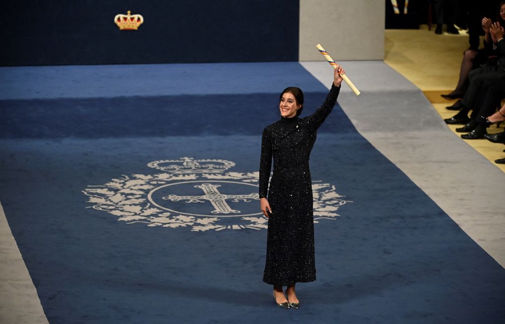 Plano entero de Carolina Marín mostrando su premio Princesa de Asturias a la audiencia 