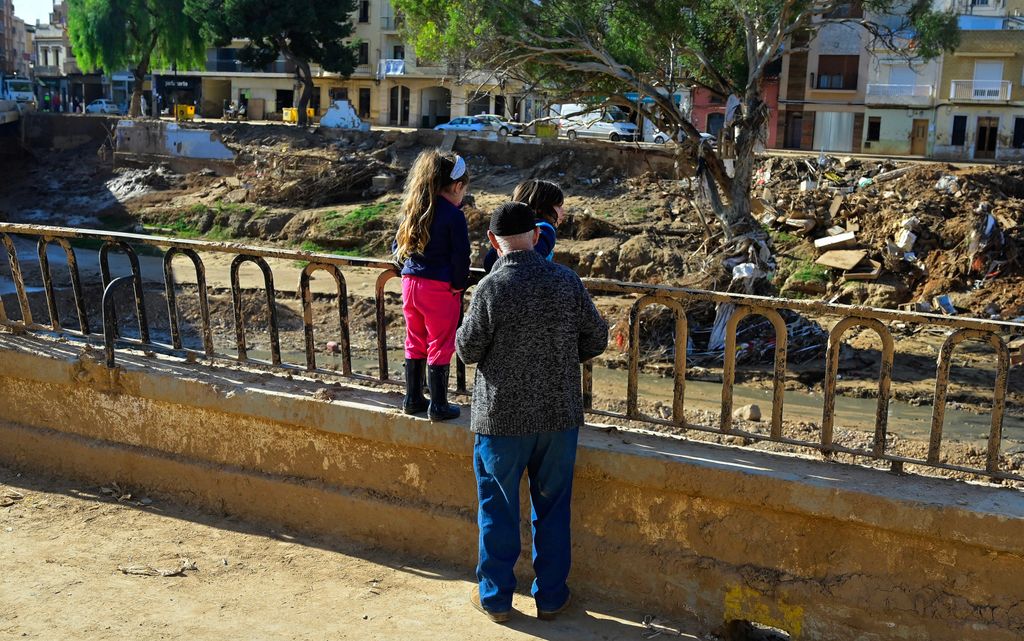 Abuelo con sus nietos observando las zonas afectadas por la DANA