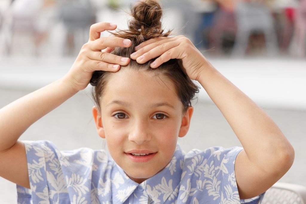 Niña con el pelo recogido con piojos