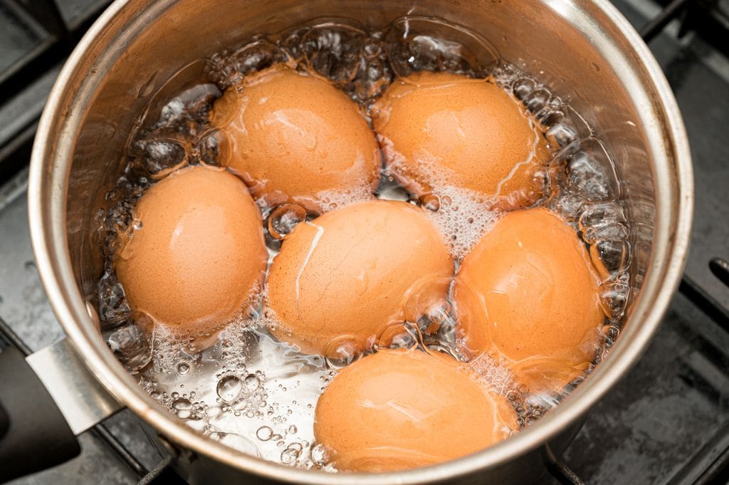 Huevos hirviendo con agua dentro de un cazo.
