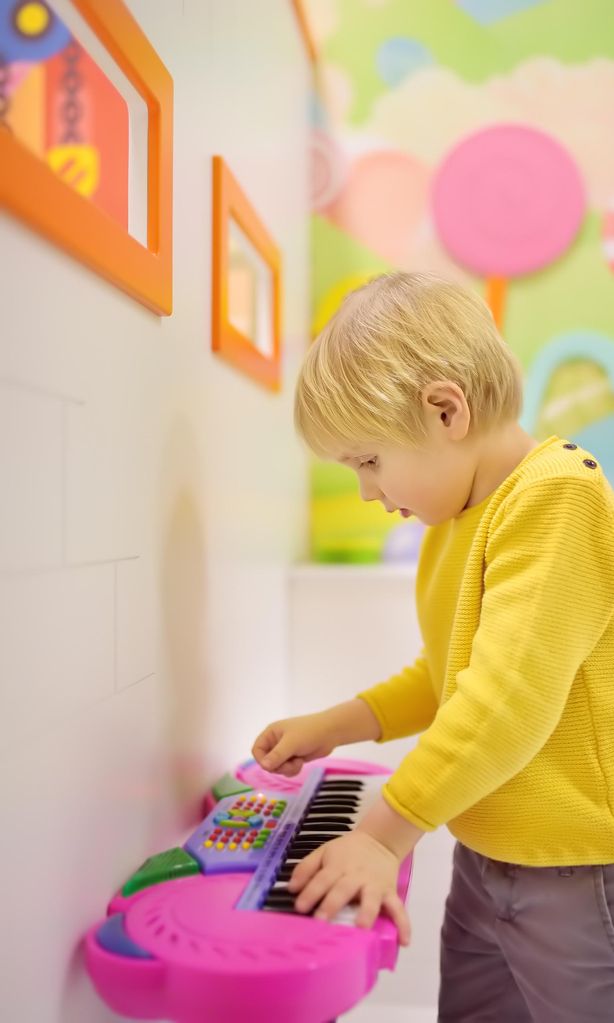 Niño jugando con un órgano de juguete