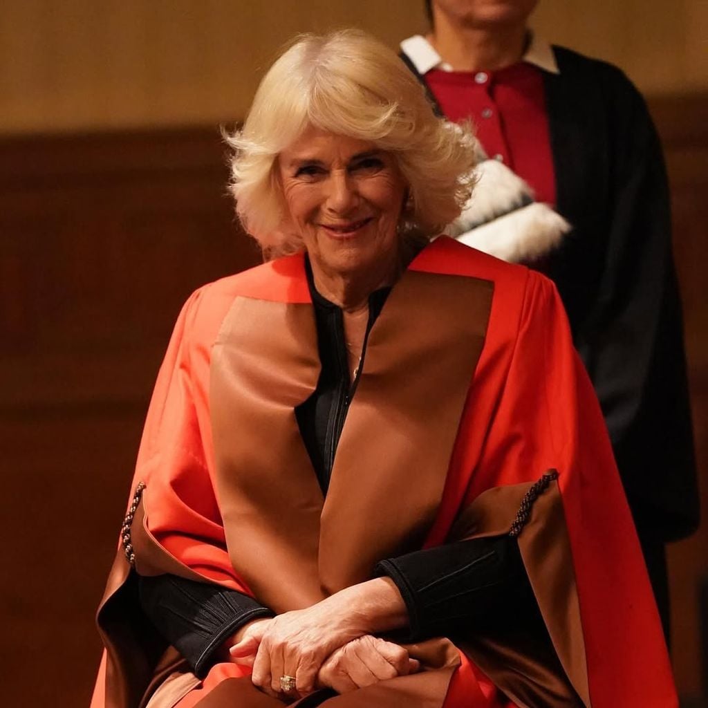 Plano medio de la Reina Camilla sentada en una ceremonia de doctorado honoris causa
