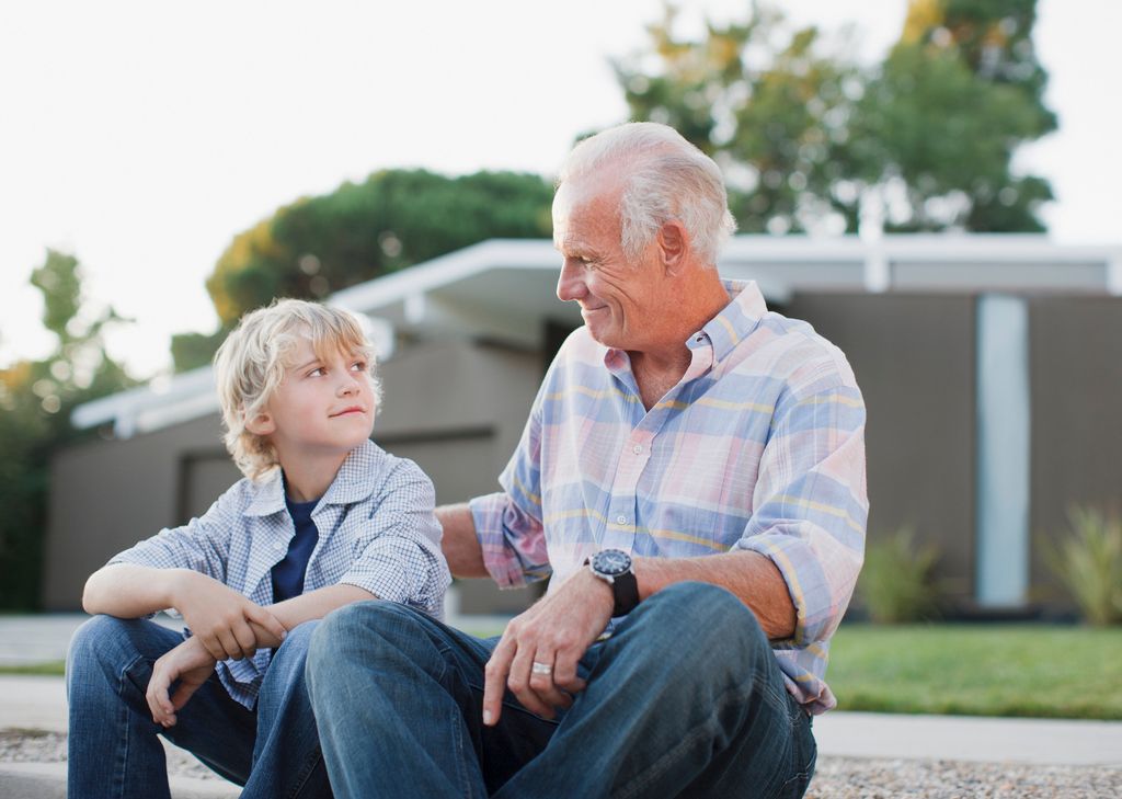 abuelo con su nieto, sentados en la calle
