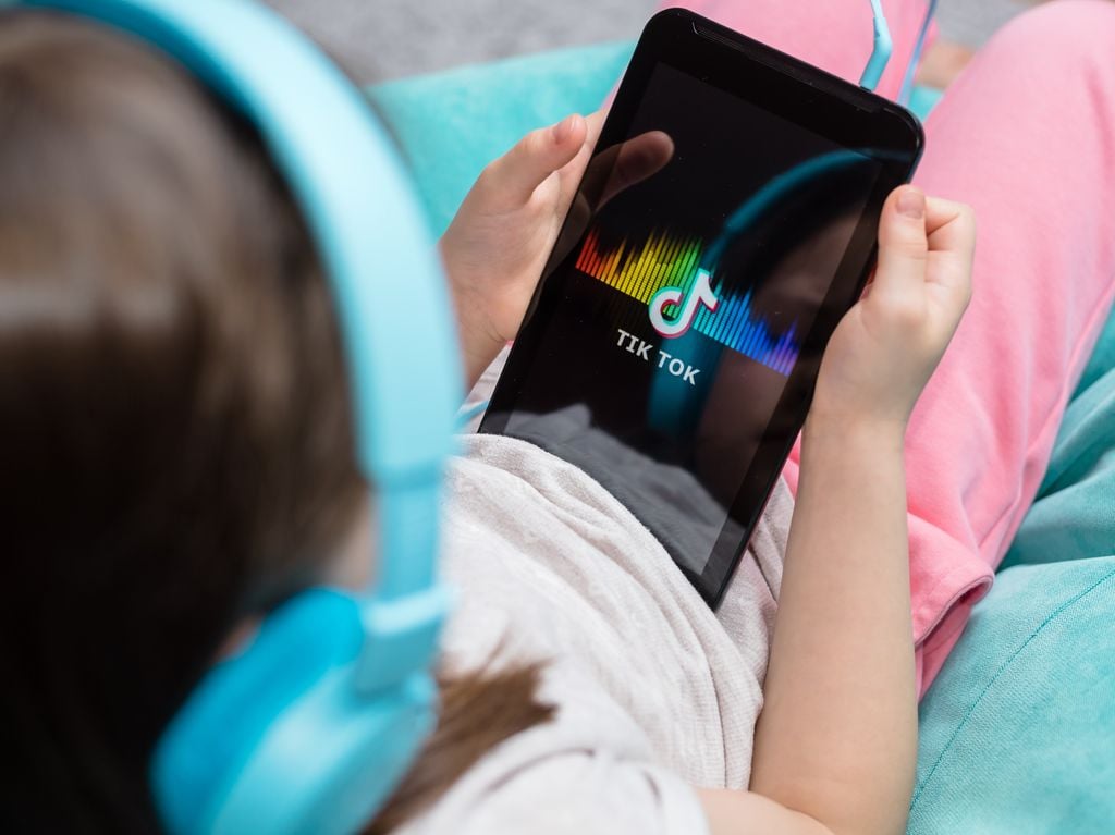 Niña usando TikTok en una tablet