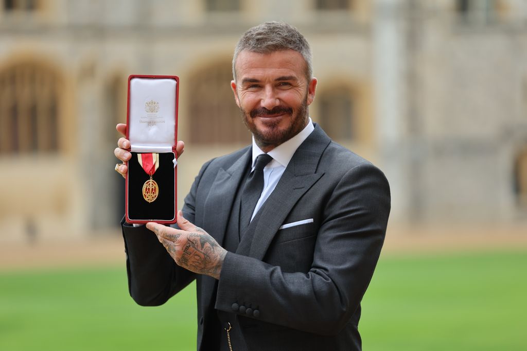 David Beckham posó sonriente con la insignia que avala su título como Caballero.