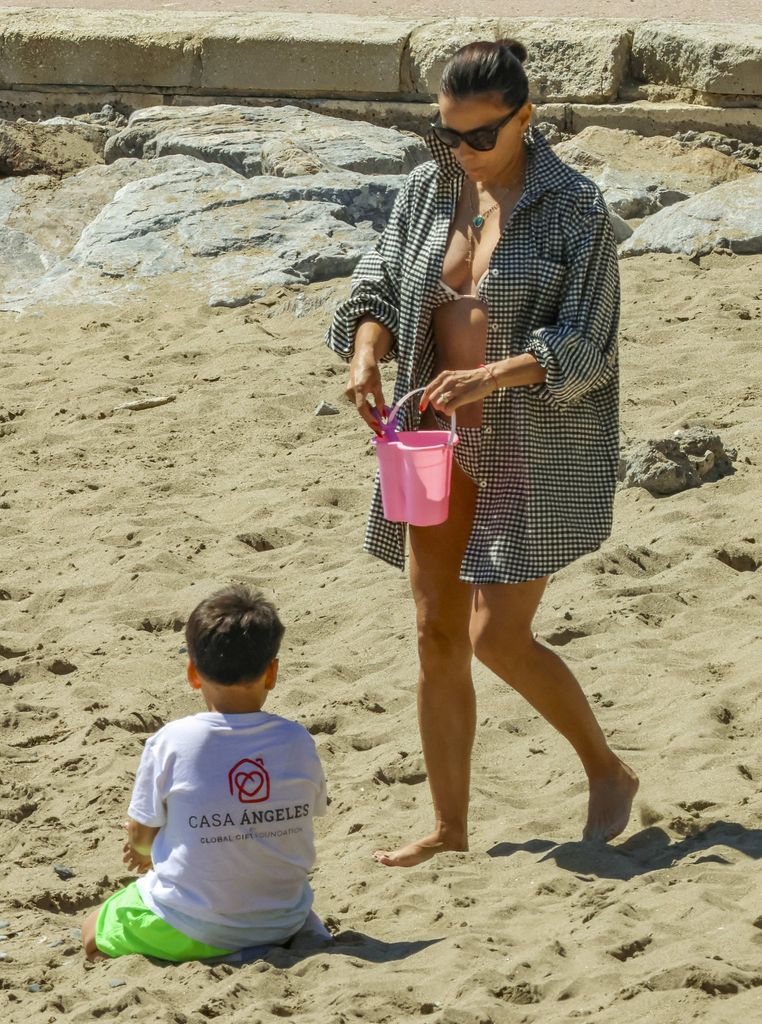 La actriz lució una camisa oversize de cuadros vichy a juego con su bikini mientras pasaba tiempo junto al mar con su familia.