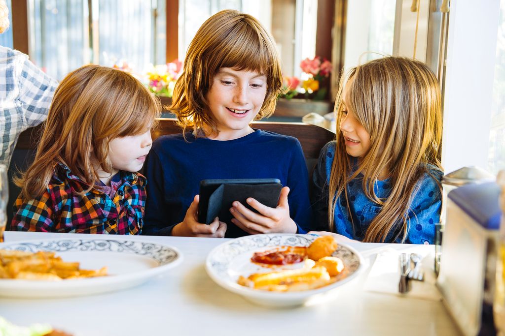 niñas usando la tablet mientras comen 