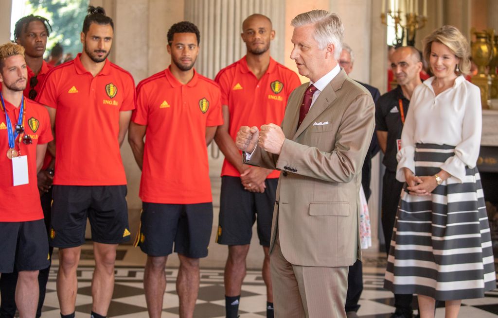 La reina Matilde de Bélgica y el coach Roberto Martinez observan al rey Felipe de Bélgica, mientras este se dirige a la selección belga, en la recepción de bienvenida a los jugadores tras el Mundial de Rusia 2018, donde fueron eliminados por Francia en la semifinal, ocupando el tercer lugar del torneo.