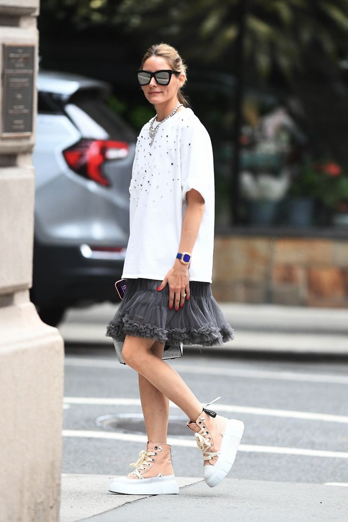 La modelo e influencer de moda Olivia Palermo luce una camiseta blanca cuadrada combinada con una falda gris esponjosa mientras va de compras por Nueva York.