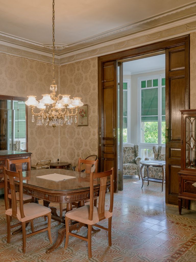Comedor con muebles de estilo clásico y paredes de papel pintado