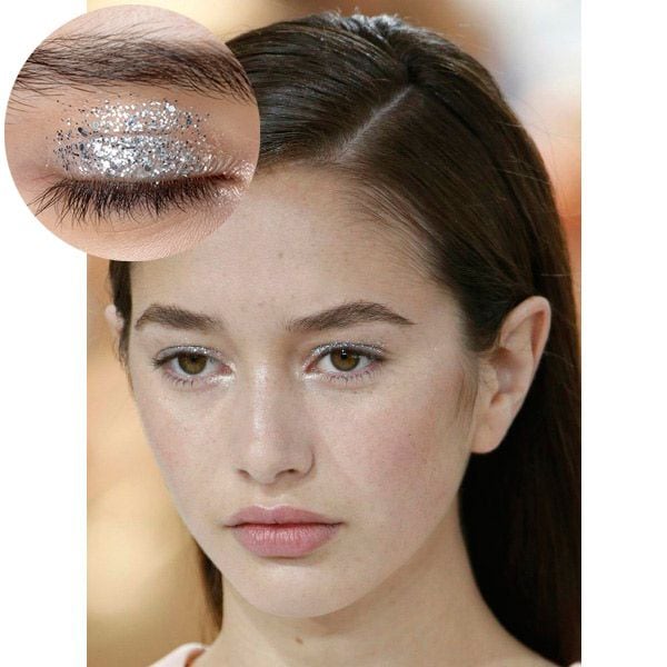 Glitter en gel en el párpado superior, con iluminador en crema en el lagrimal formando una 'uve' y maquillaje de mejillas y labios al natural.
