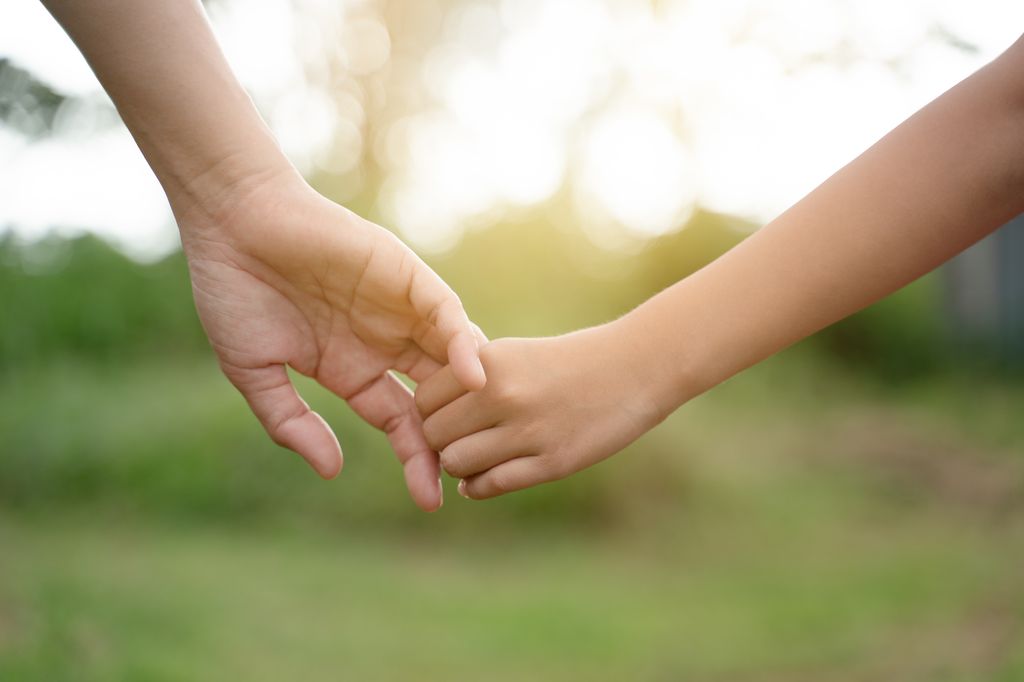 mano de madre e hija juntas al aire libre