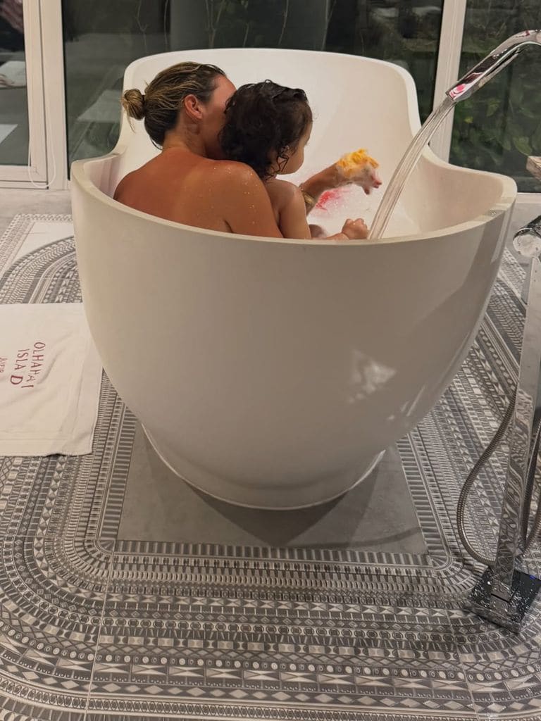 Madre e hija jugando en la bañera del hotel