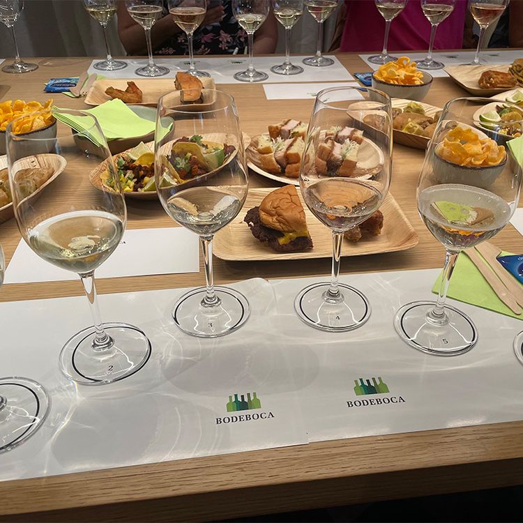 Copas de champán con platos de comida detrás