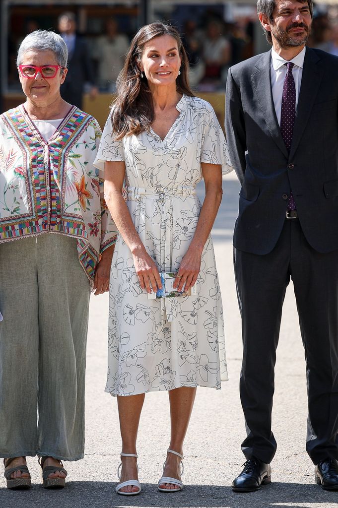 La reina Letizia con vestido blanco con estampado floral y sandalias bajas blancas en la Feria del Libro de Madrid 2025