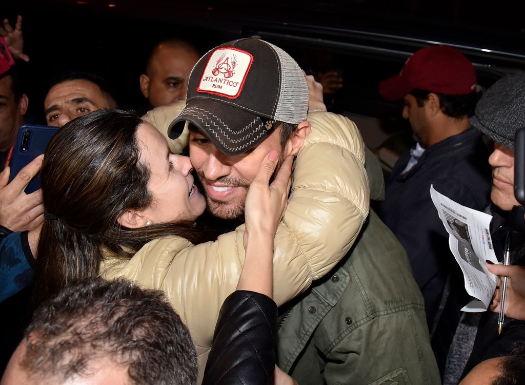 Primer plano de Enrique Iglesias dando un abrazo a una fan