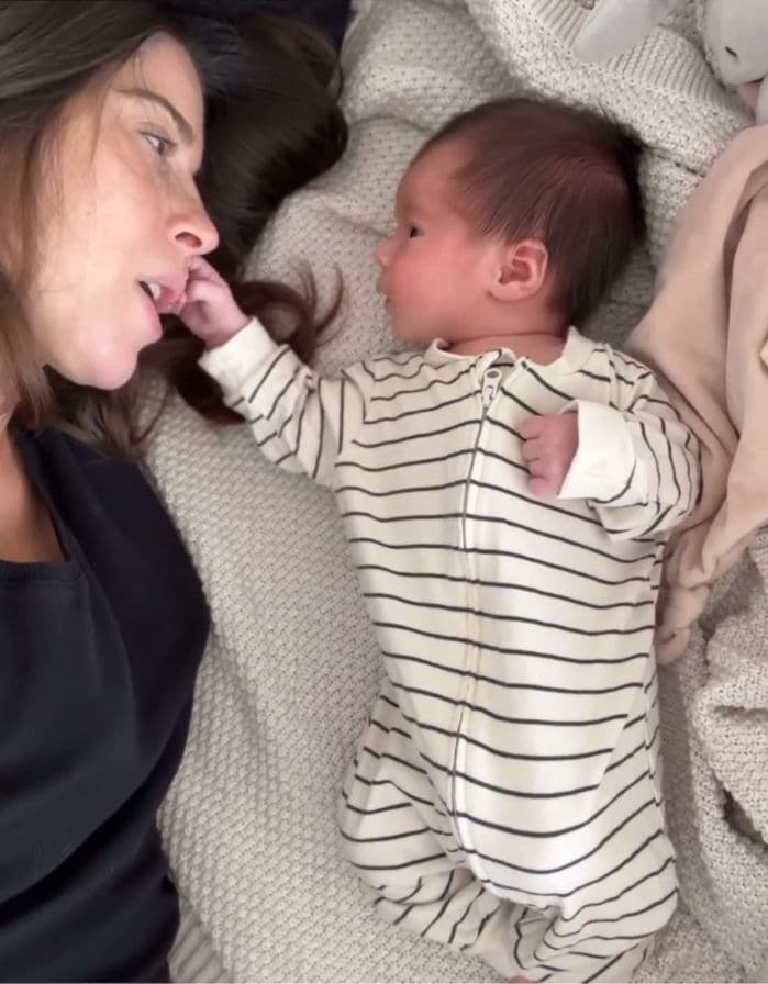 Plano medio de Marta Riumbau con su bebé tumbada en una cama