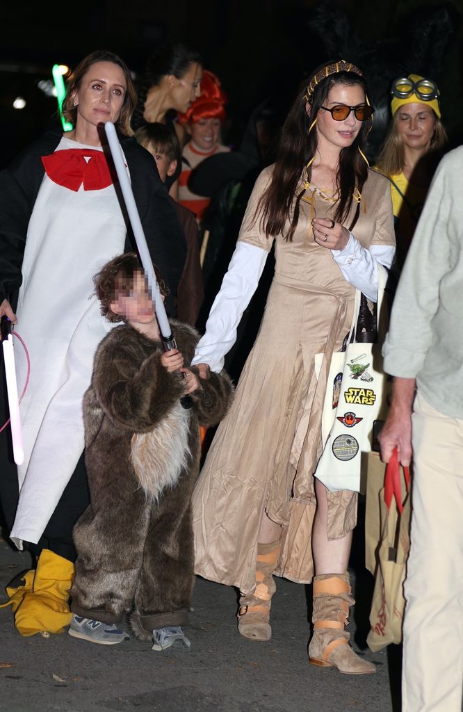 Plano entero de Anne Hathaway disfrazada de Halloween con su hijo