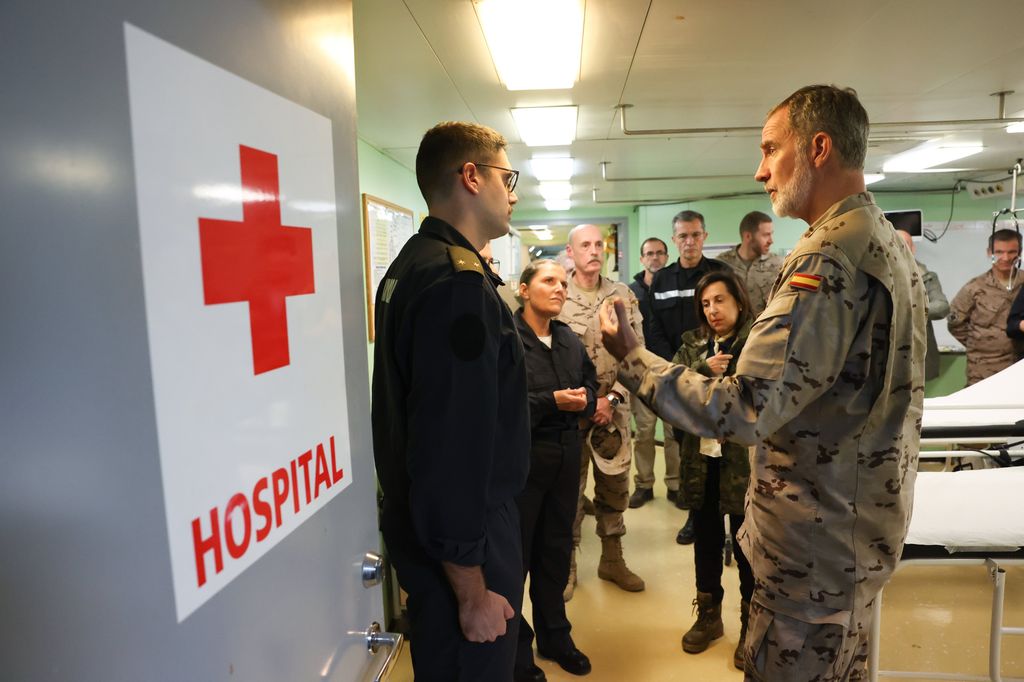 Plano medio del rey reunido en un hospital con algunos militares