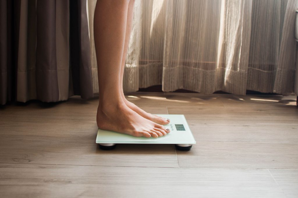 mujer pesándose en una báscula