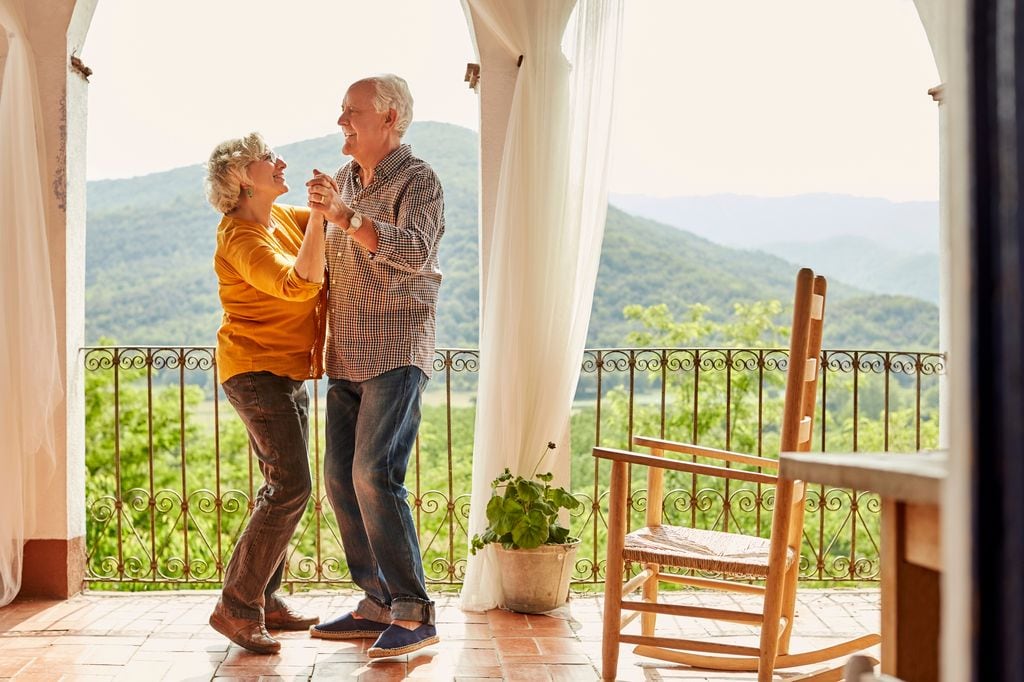 pareja de ancianos bailando en su terraza felices