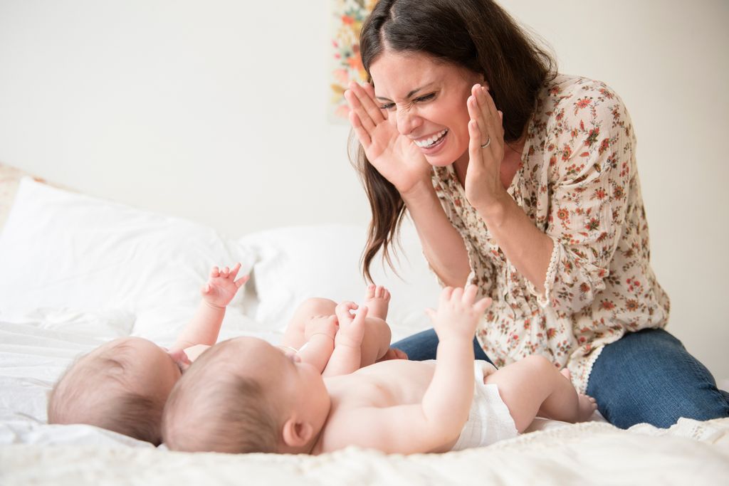 Madre con bebés gemelos jugando en casa