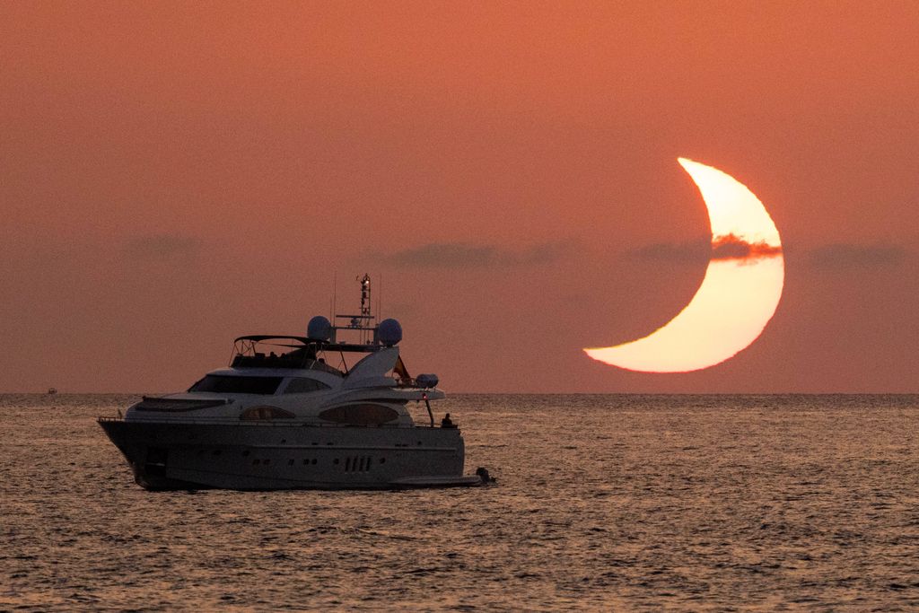 El eclipse dibuja una espectacular media luna sobre el mar de Sant Antoni de Portmany, en Ibiza,