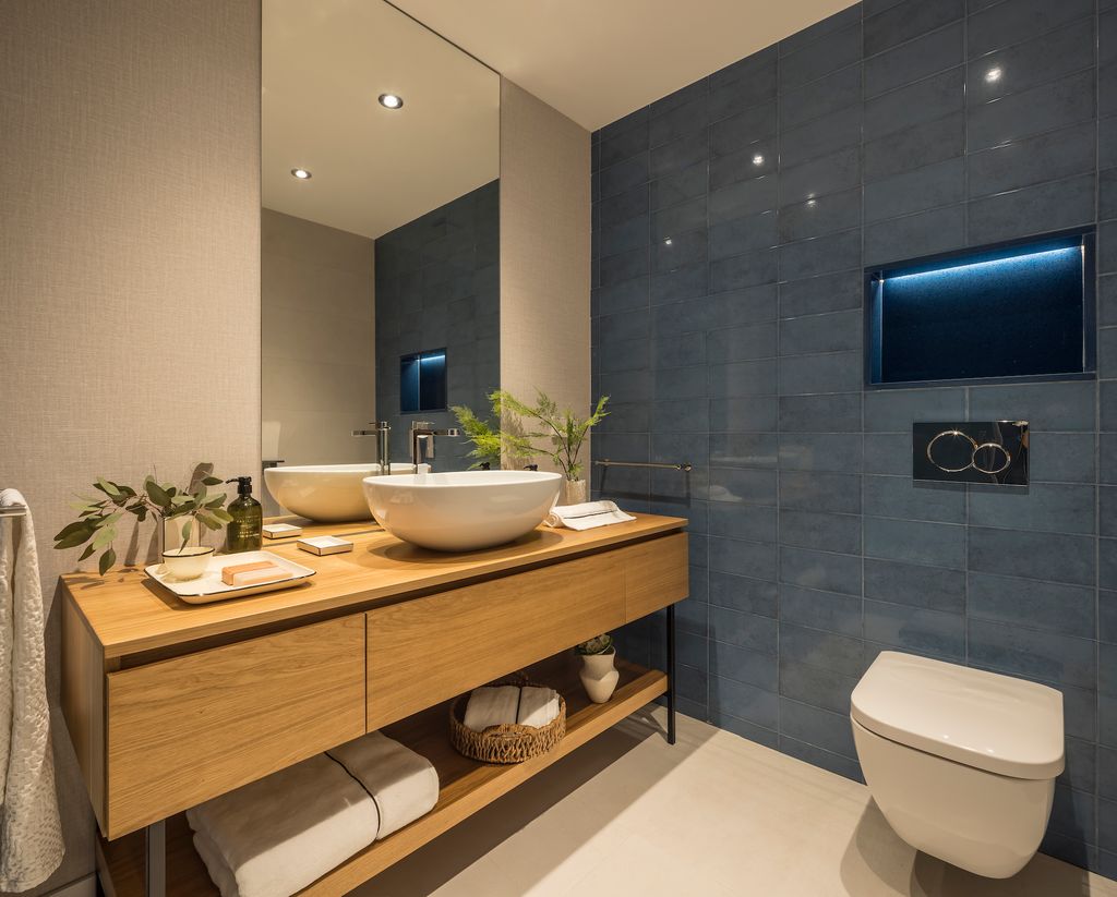 Baño con inodoro con cisterna empotrada con hornacina encima.