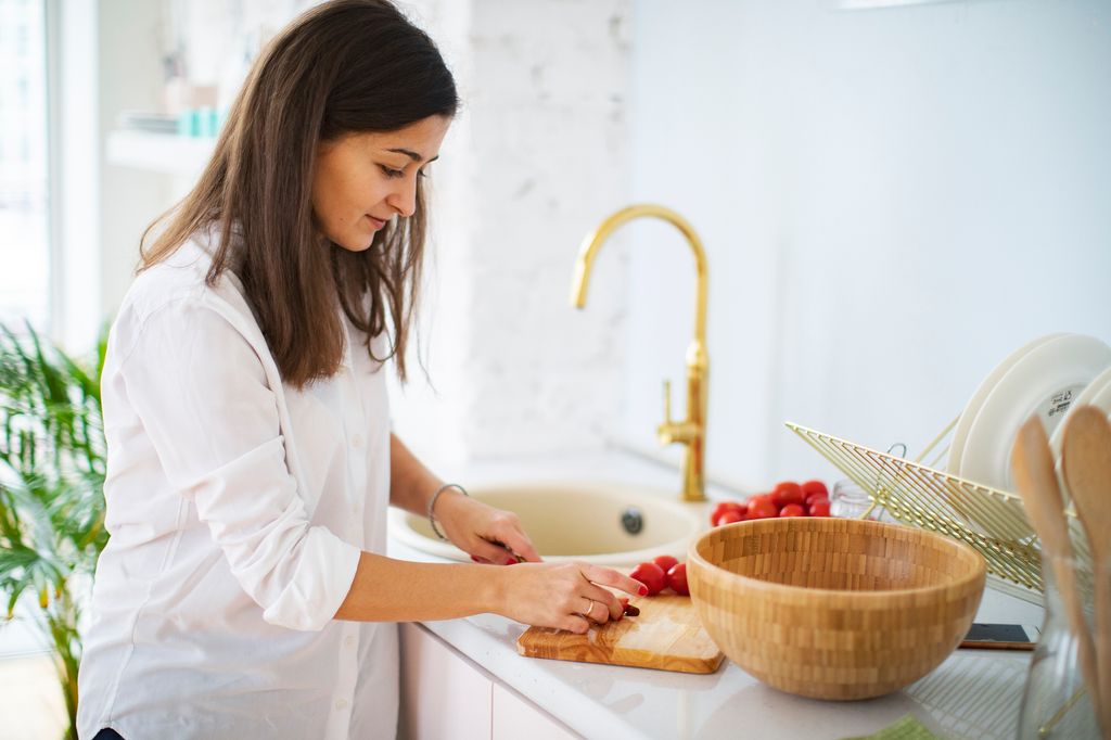Mujer limpiando la ensalada bajo el grifo