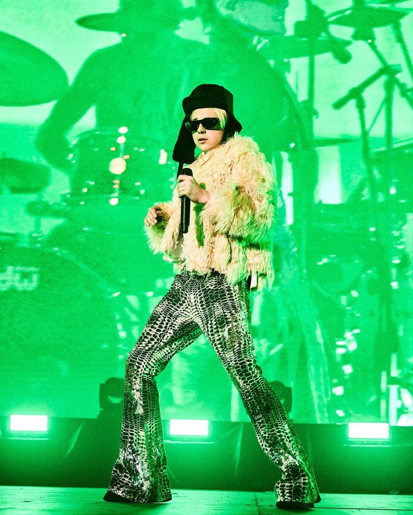 Plano entero de Paco Amoroso durante uno de sus conciertos con abrigo de pelo y pantalon animal print