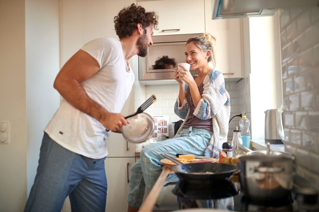 pareja feliz en la cocina, preparando el desayuno, cocinando juntos
