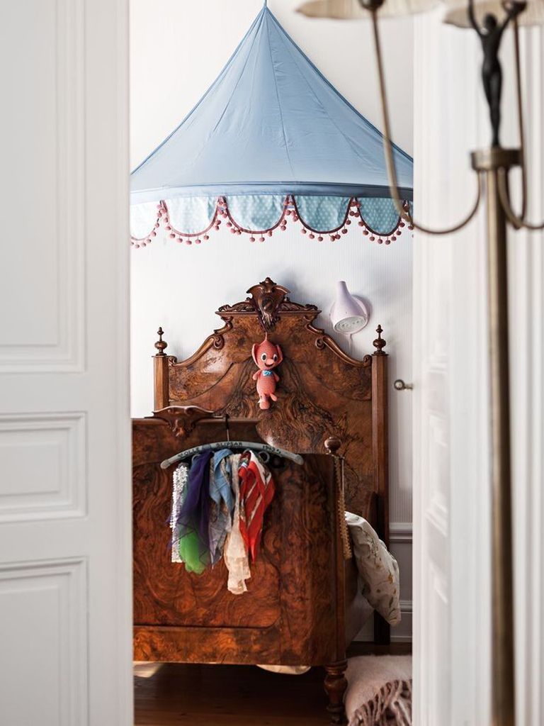 Cama de madera oscura con dosel a modo de carpa de circo
