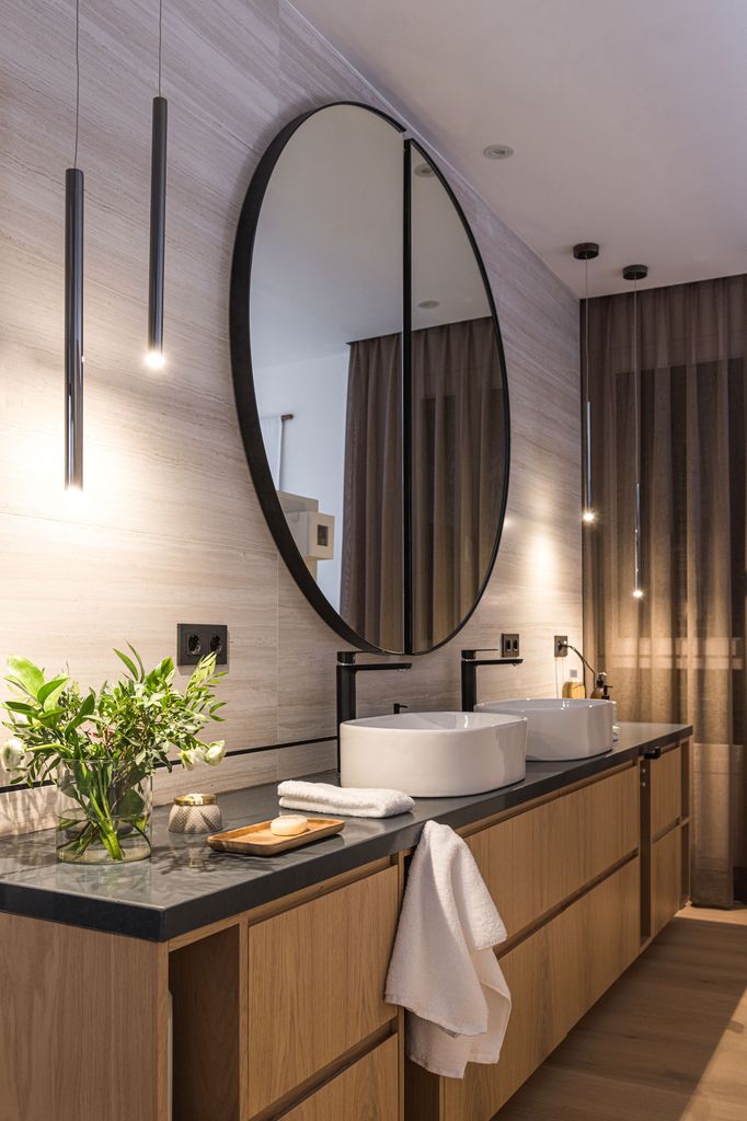 Baño moderno con espejo redondo. 