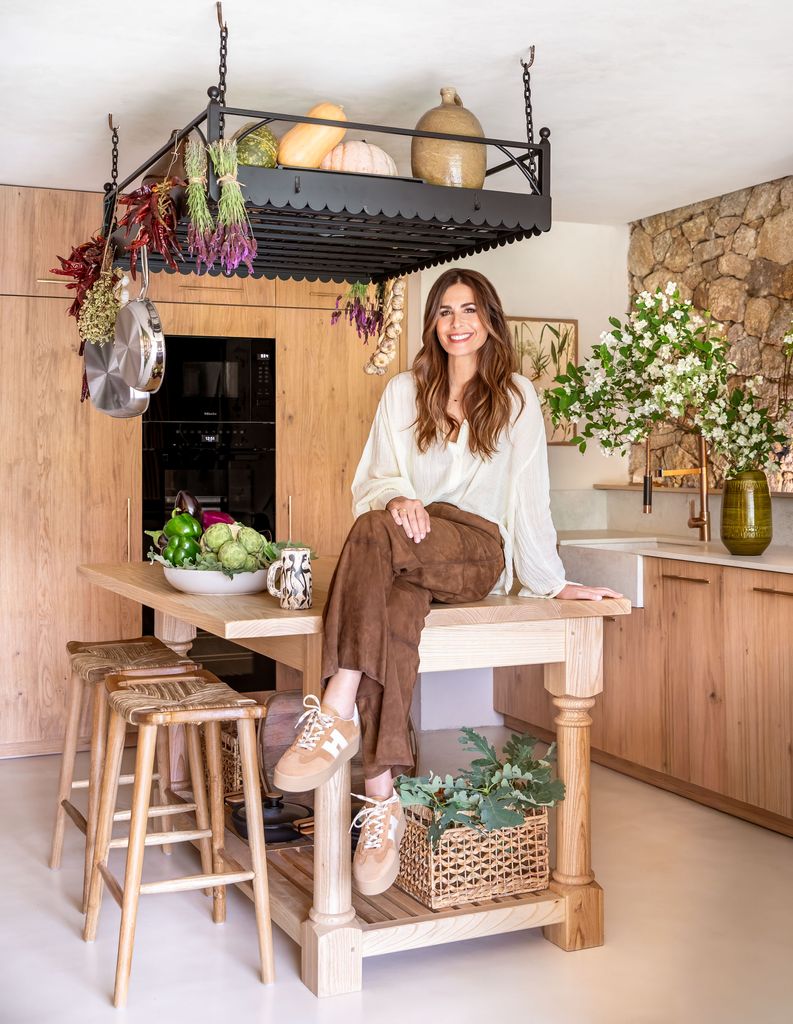 Nuria Roca posa encima de la isla de madera de su cocina en Candeleda