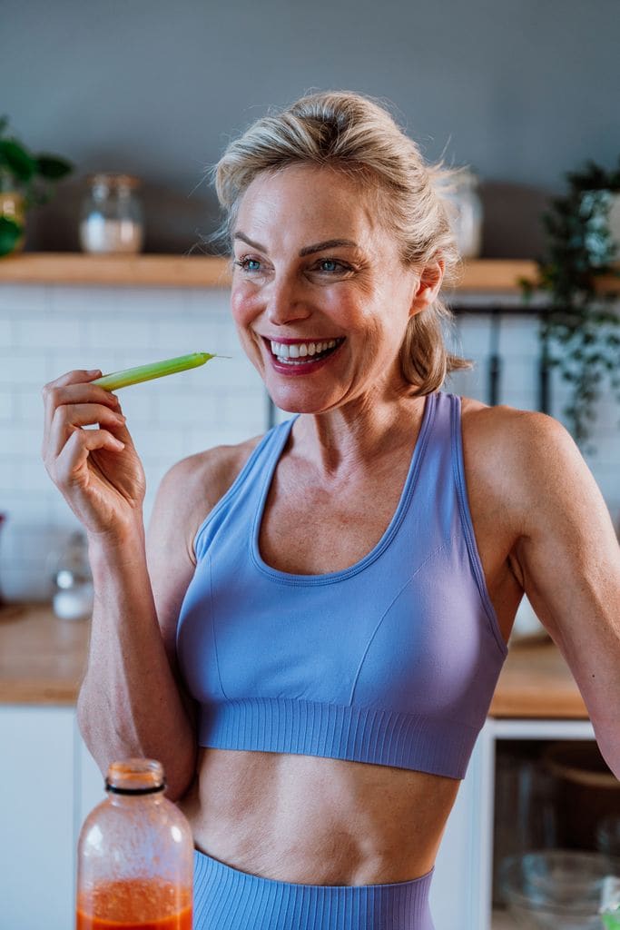 Una mujer adulta de 50 años en la cocina con ropa deportiva