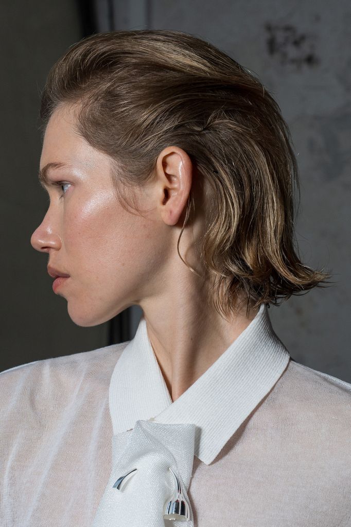 Modelo con pelo hacia atrás y camisa blanca