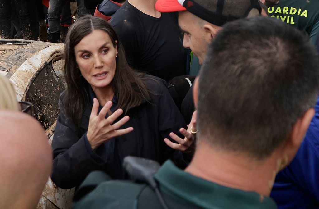 Plano medio de la reina Letizia en su visita a Valencia hablando con un vecino afectado
