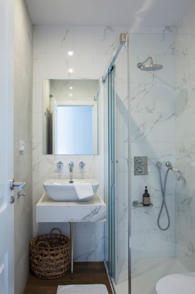 Baño pequeño con paredes y lavabo con acabado mármol.  