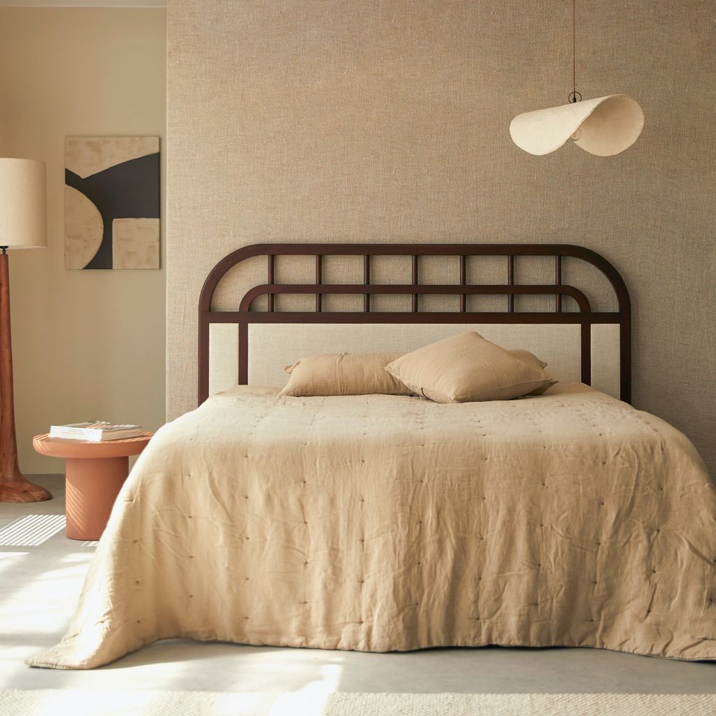 Dormitorio con cabecero de madera curvo