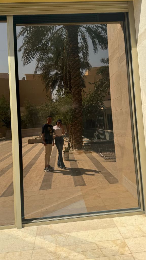 Plano entero de Georgina Rodríguez y Cristiano Ronaldo en el reflejo de una ventana