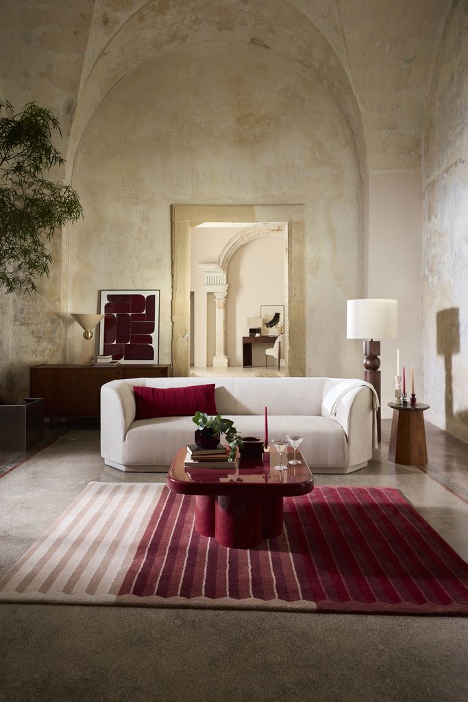 Salón con sofá blanco y mesa de centro y alfombra en rojo