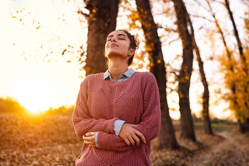 mujer joven respirando en el campo