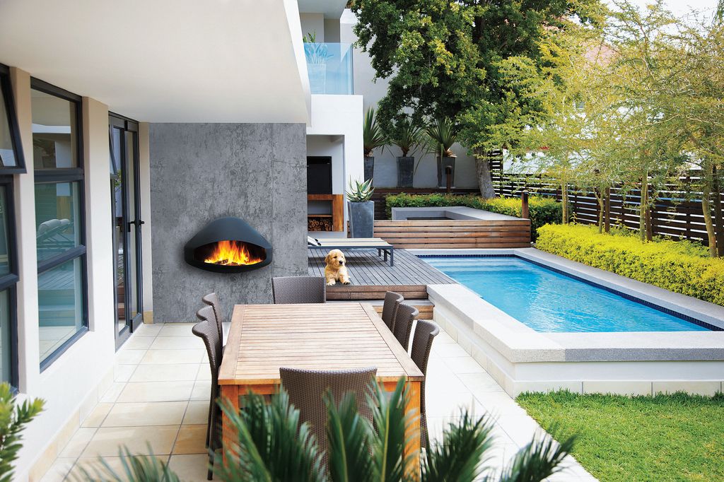 Chimenea mural en un jardín con piscina