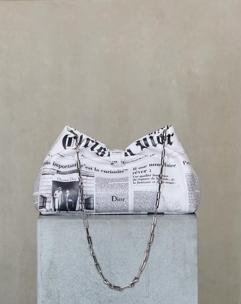 Bolso 'Dior Bow' en piel con estampado de periódico que forma parte de la colección Crucero 2027 de la firma francesa