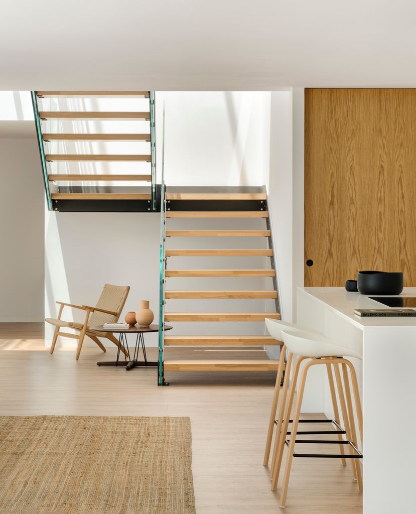 Escalera doméstica con pisada de madera y barandilla en cristal